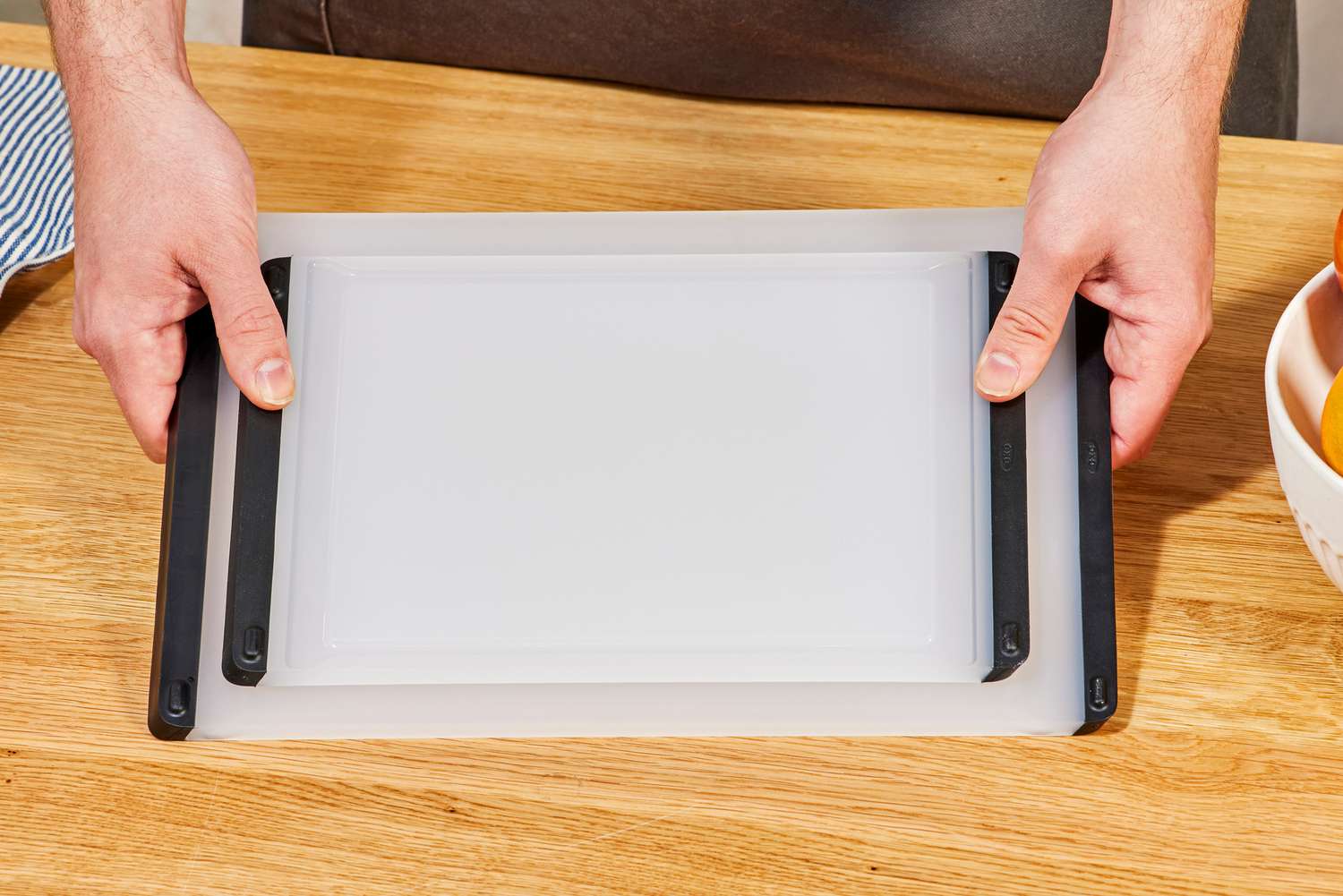 A person placing two OXO cutting boards down onto a countertop.