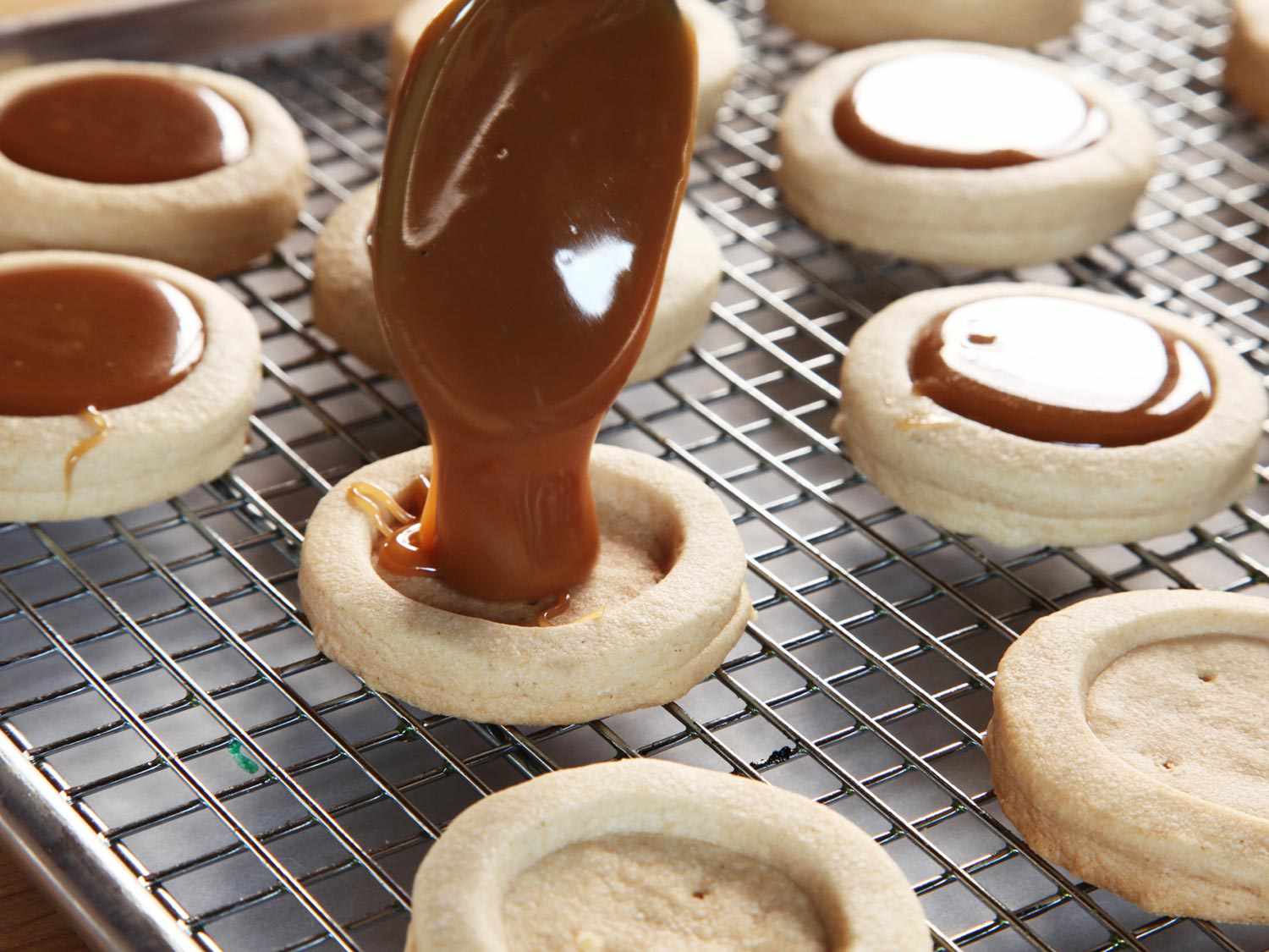 Filling the short bread cookie base with caramel sauce. 