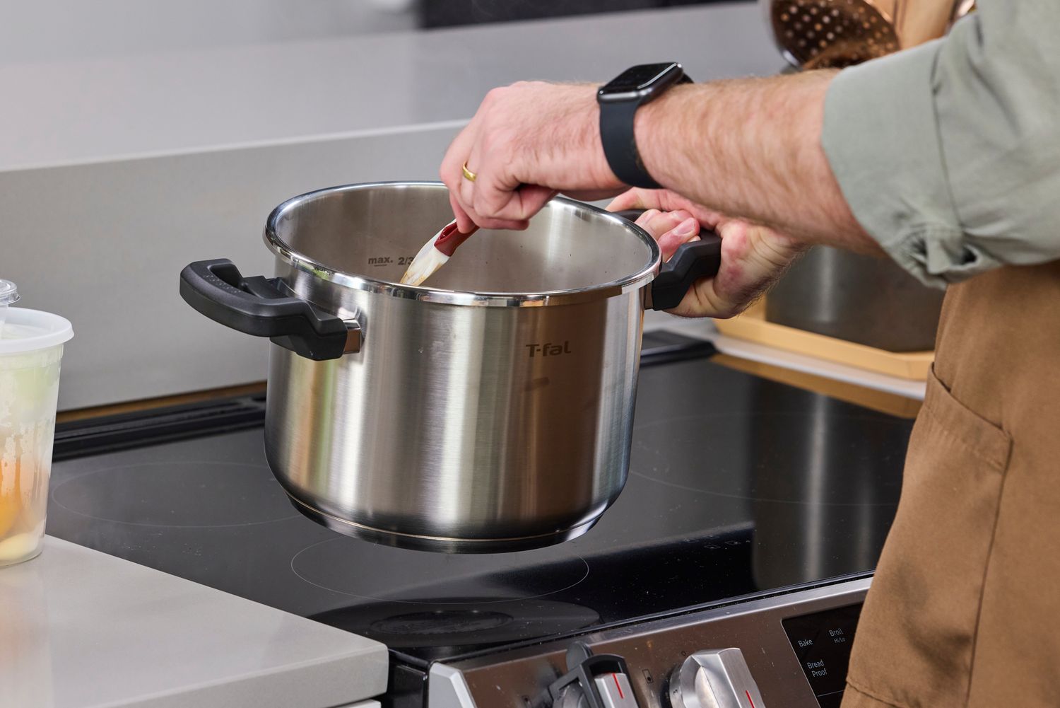 A person stirring the contents of the T-Fal Clipso Pressure Cooker