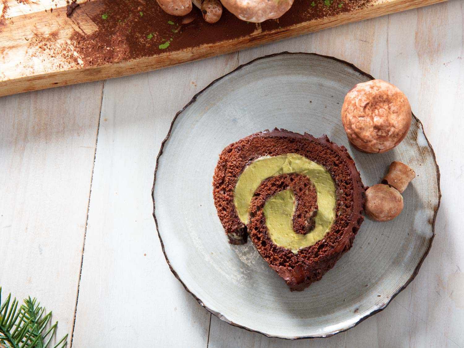 Overhead shot of a Yule log slice, garnished with a meringue mushroom. 