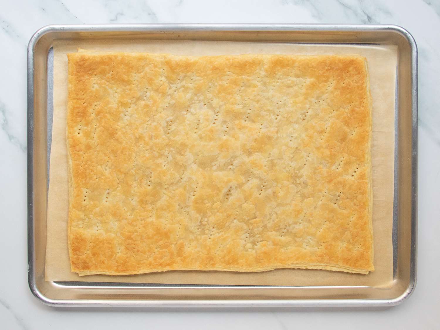 Sheet of par-baked puff pastry set in rimmed baking sheet