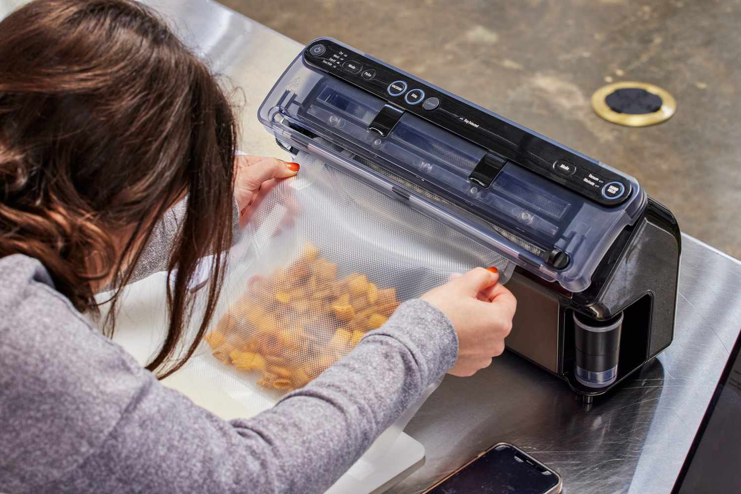 A person vacuum seals Chex Mix using the FoodSaver VS5960 Elite All-in-One Liquid+ Vacuum Sealer