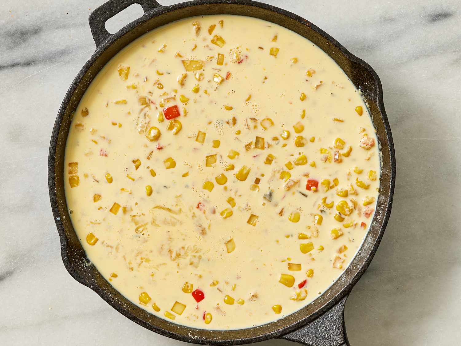 Overhead view of adding dairy corn casserole