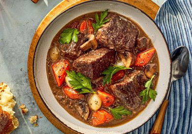A bowl of beef bourguignon with big chunks of juicy beef, plump carrots, mushrooms and more.