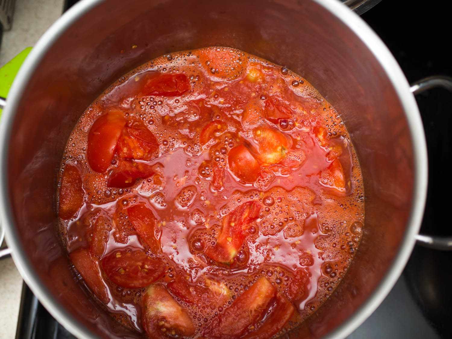 Tomatoes being cooked down in a pot to make passata.