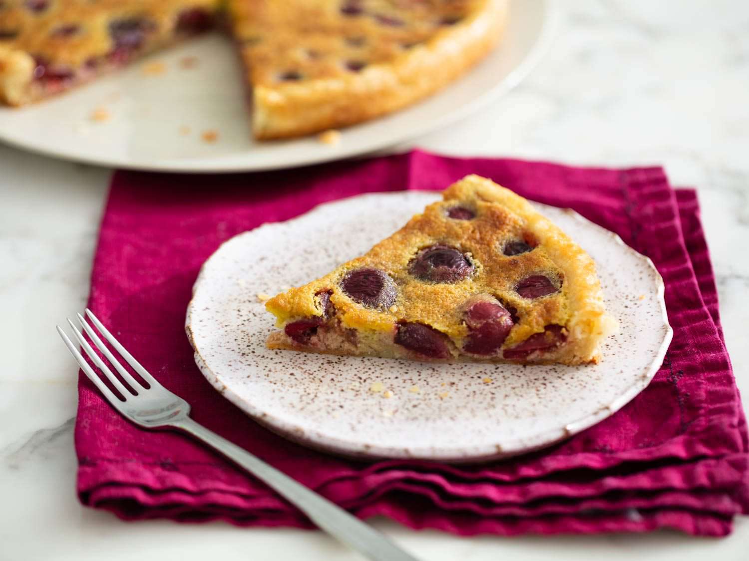 a slice of cherry frangipane tart