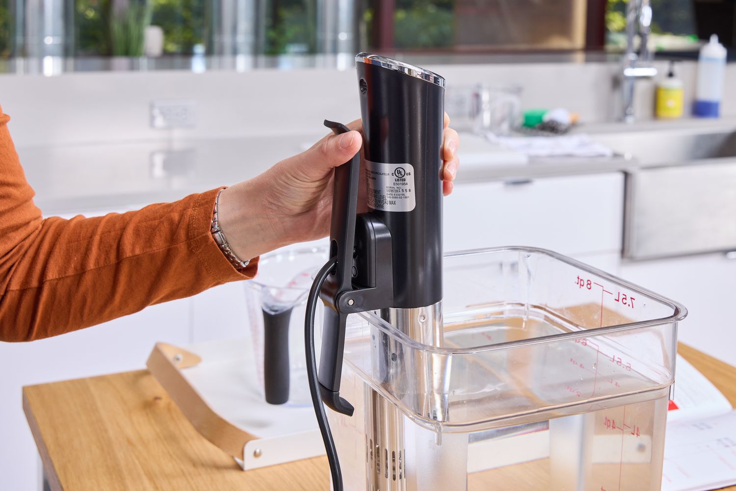 A person presses the clamp on the Instant Accu Slim Sous Vide Immersion Circulator
