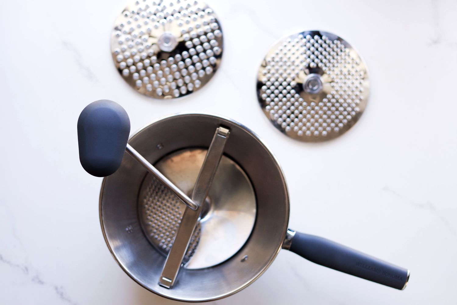 The Williams Sonoma food mill with two extra plates on the side