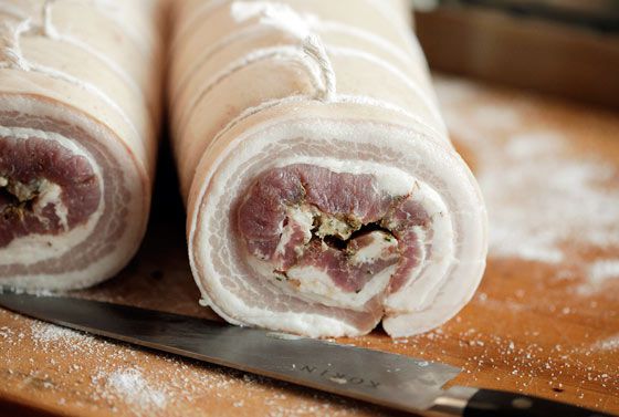 Rolled and tied pork belly cut into two logs