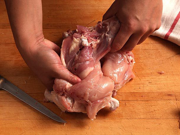 Grasping and lifting the entire leg upward to pry ball joint of the its socket