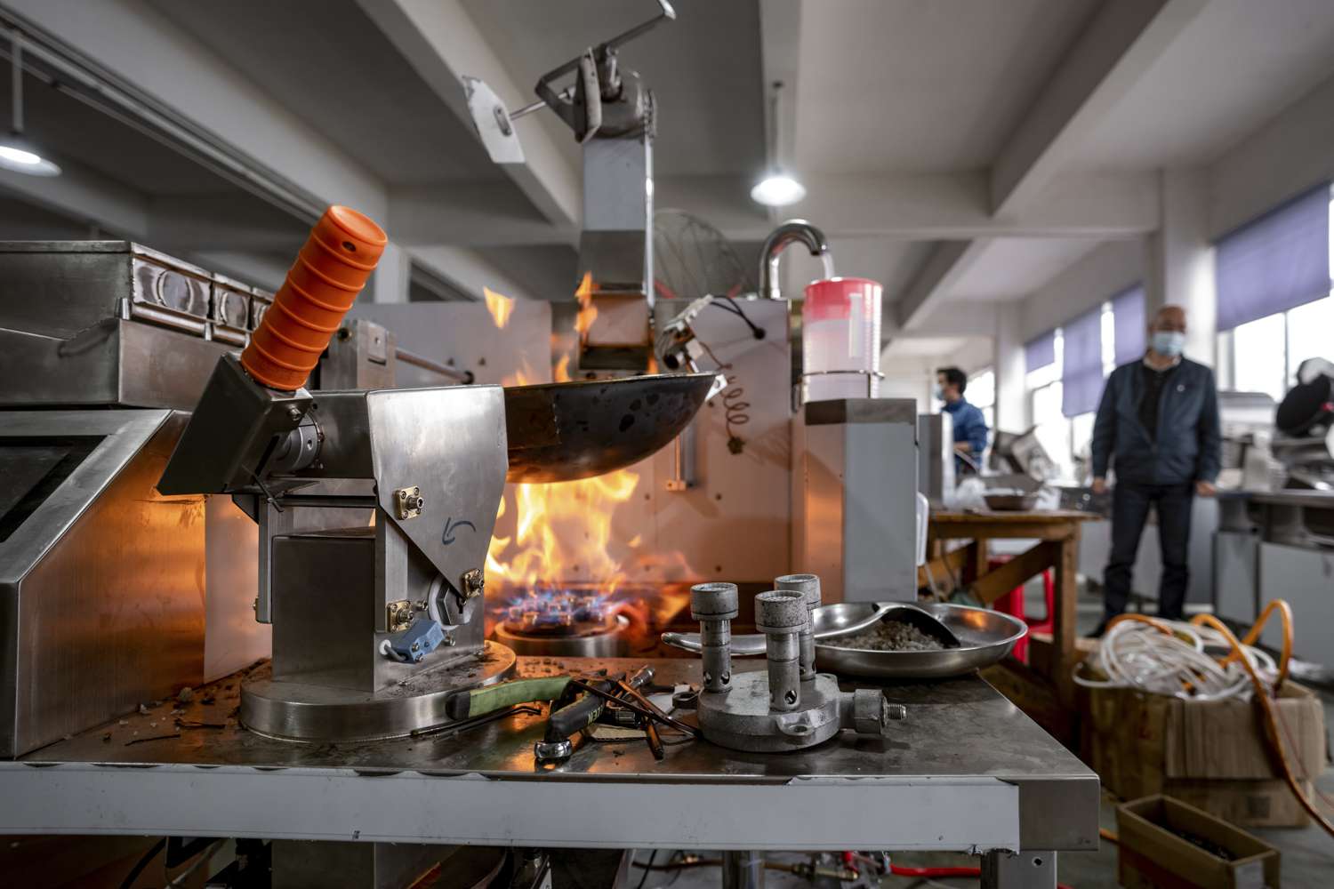 A machine firing a wok in a factory 