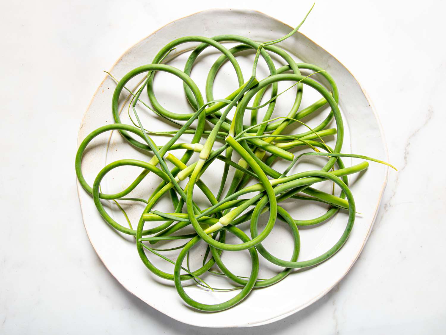 Garlic scapes arranged ona a plate in a overlapping circle pattern