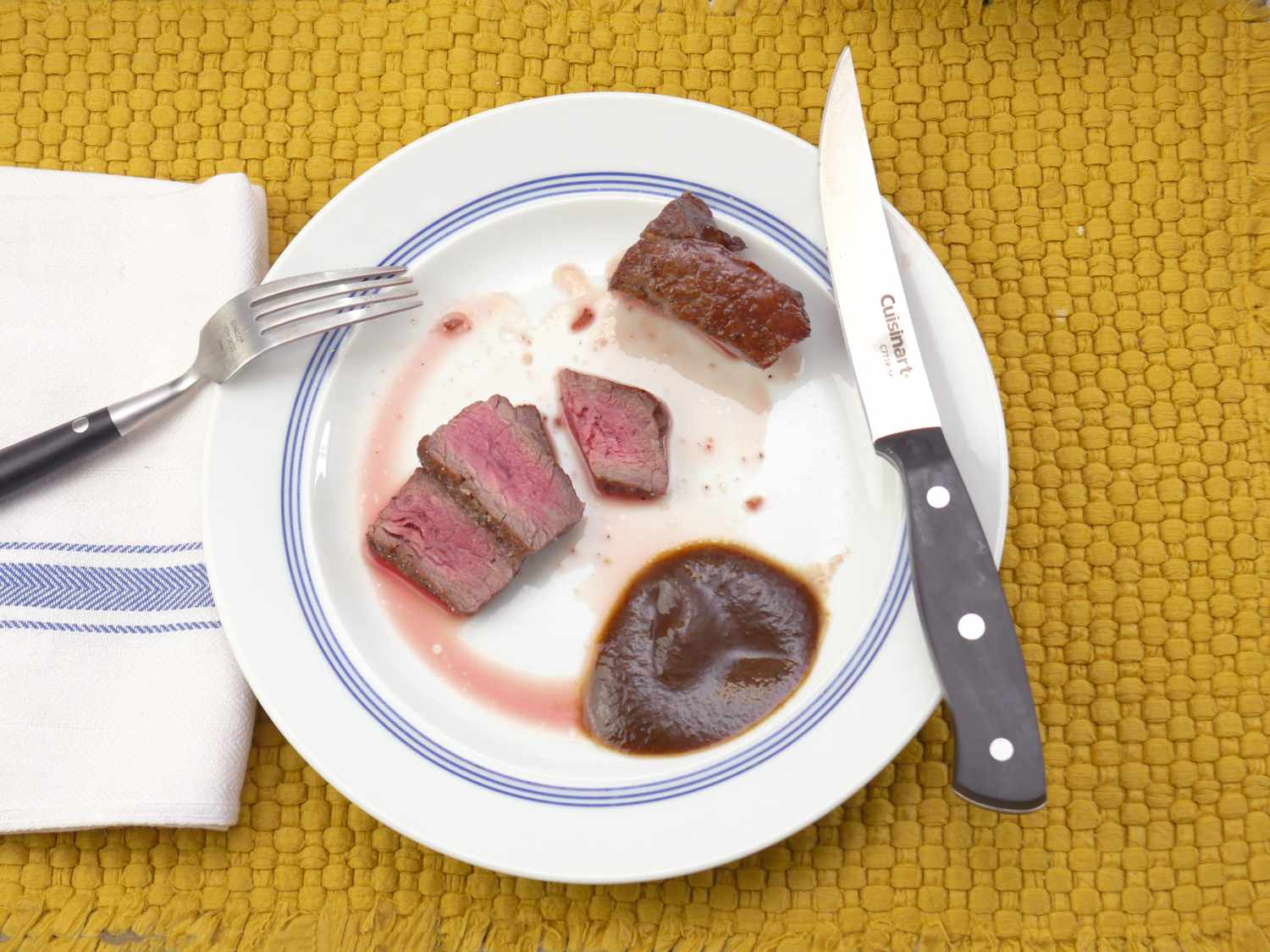 a cuisinart steak knife on a plate with sliced meat
