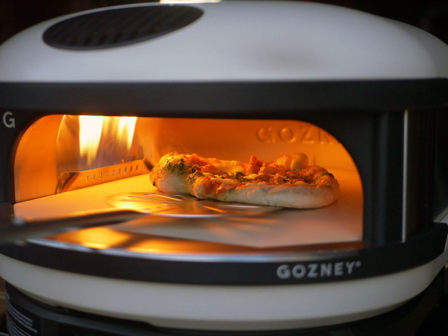 a pizza turner being used to turn a pizza inside the gozney arc