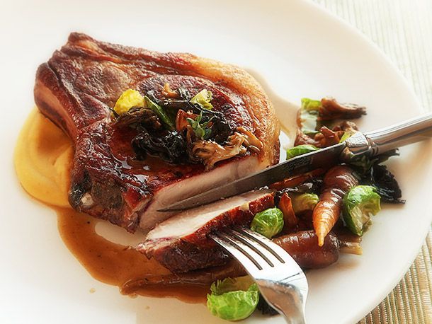 Slicing into a reverse-seared pork chop with a knife and fork.