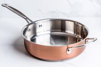 A pot from the Cuisinart Copper Collection Tri-Ply Cookware 8-Piece Set on a white surface
