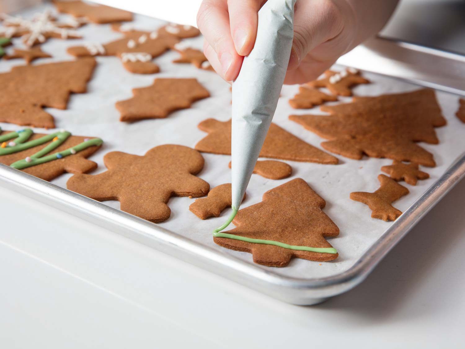 Decorating gingerbread cookies with royal icing.