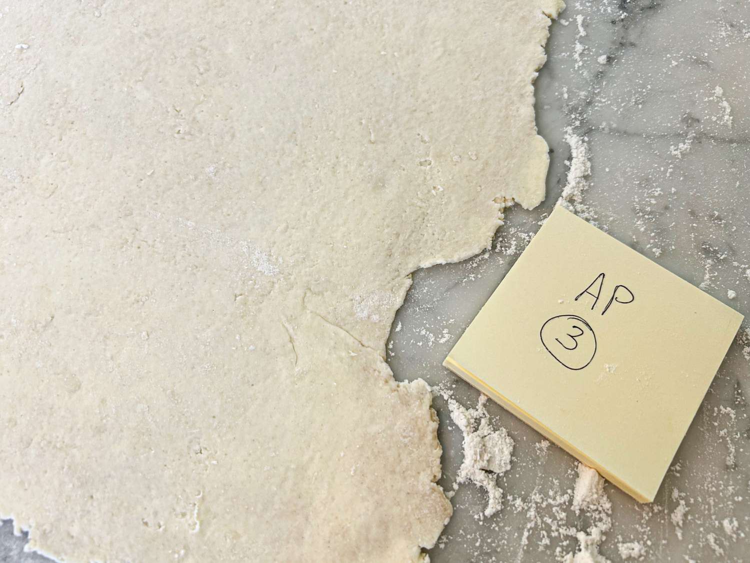 Rolled out pie crust on a countertop with a sticky note labeled AP 3 nearby