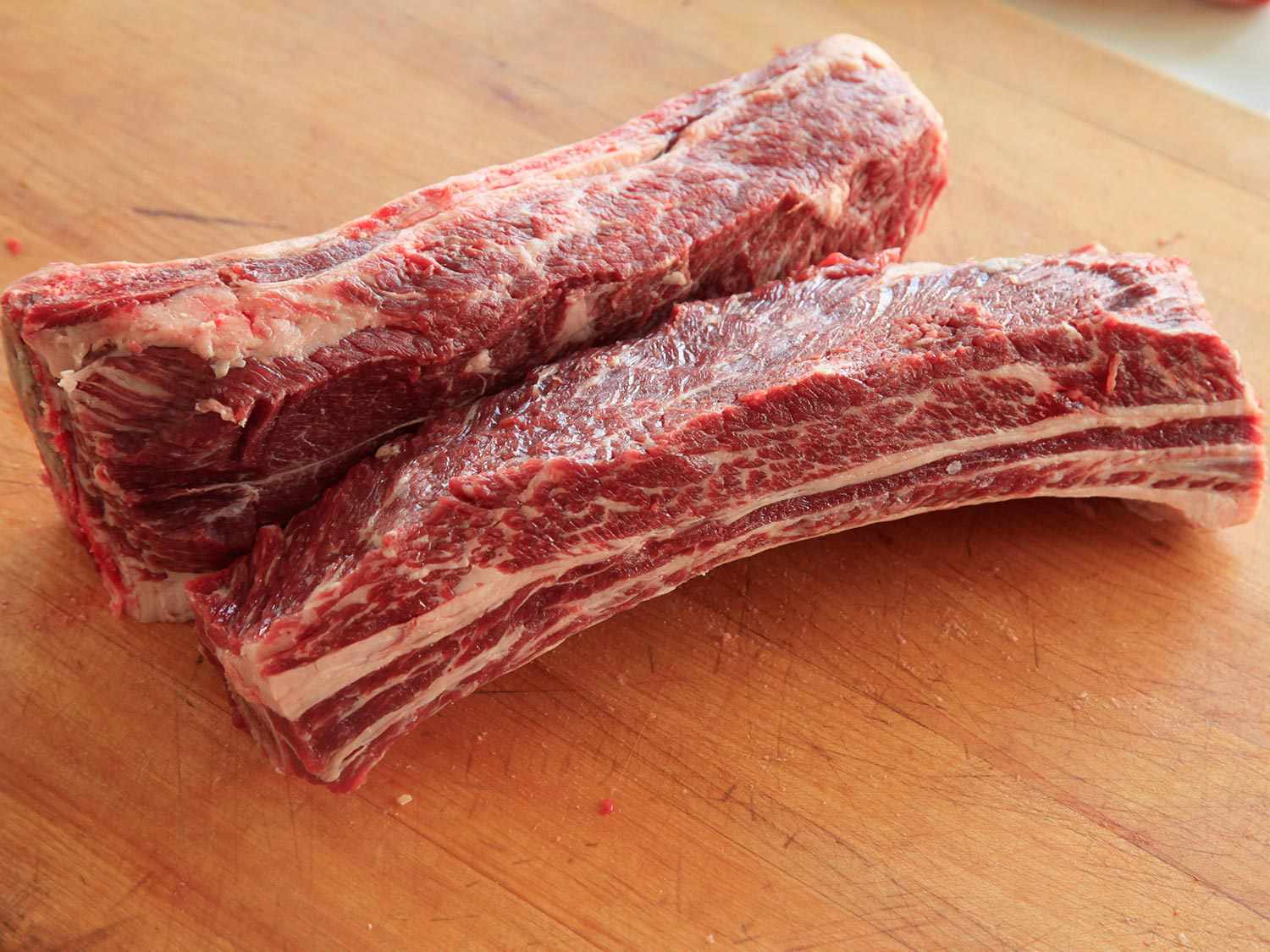 Raw short ribs on a wooden surface
