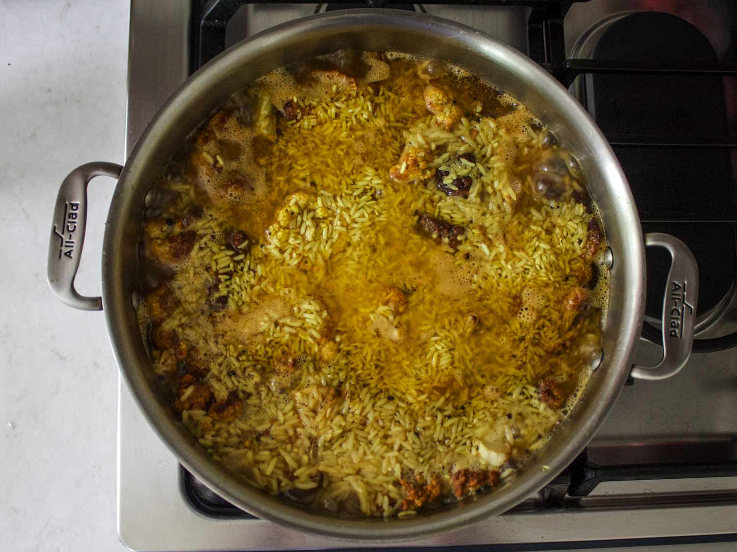Maqlubeh with stock brought to a boil on the stove